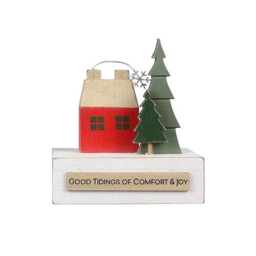 A 3D wooden decor item with a small red house and two green trees.